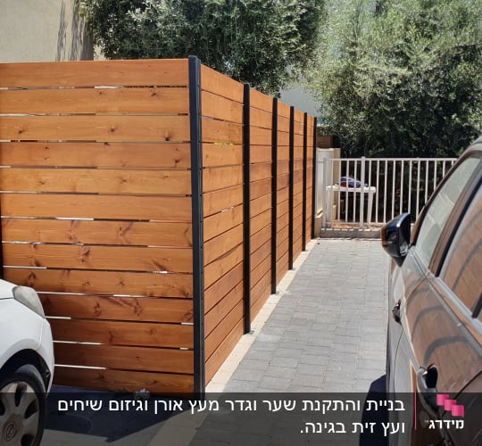 גדר עץ חומה עם עמודי מתכת שחורים
